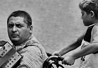 busker in wheelchair supported by his son