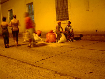 Boys sitting on bags of sawdust waiting patiently to get started on their alfombra