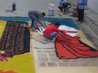 People are working fast to finish up the alfombras before the procession starts