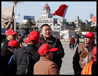 Small touristgroups keeping together on Tiananmen Square