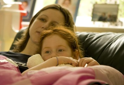Girls snuggle in front of TV
