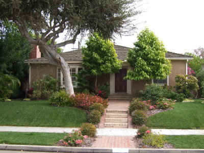 Voila!  And here is the house as it looks today! New stucco, many new plants & flowers, new trees, and new grass.