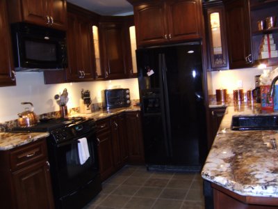 Recessed lighting in the ceiling along with lighting under the cabinets and in several cabinets make the kitchen much brighter