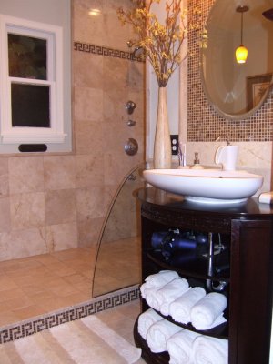 We installed an above vanity sink and you can see the step we created that leads to the very open showe -no door!