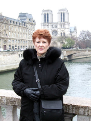 Sarah freezes outside Notre Dame on the Seine river.