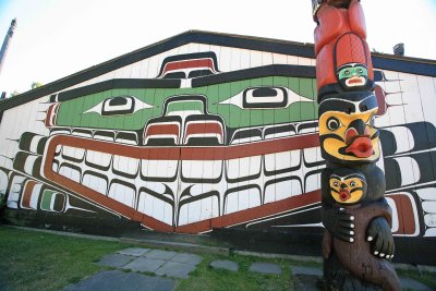 British Columbia Native  Long House  With Totem Pole In Front.