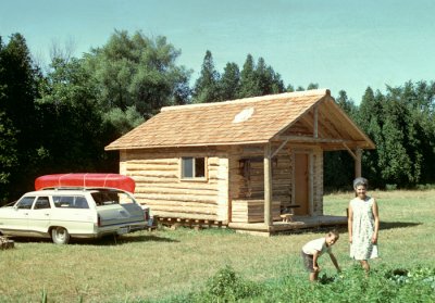 Mom/Martha in her garden with Mark, the brand new cabin beyond