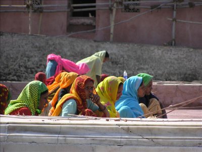 Women tapping the wet cement to remove air bubbles on a roof top