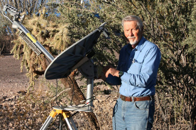 Dad sets up his Internet satellite dish again after having dismantled it for its safety during a windy night.