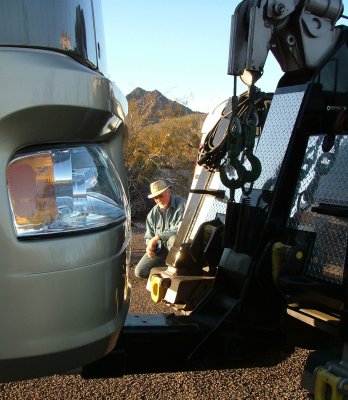 Dad watches as the tow truck is connected to the motorhome