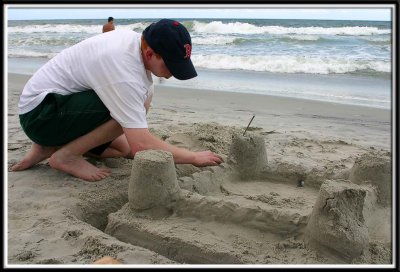 Daddy does his best to make a sandcastle fit for a Princess Noelle.