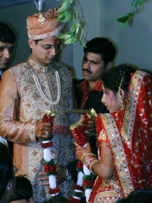 Bride and groom about to garland each other