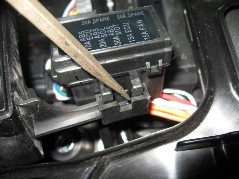 Release the clip on the fuse box so you can lift it off the mount point