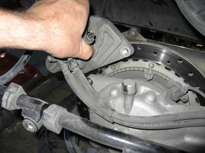 Lift off caliper once both bolts and hose clamp are removed and rest it on saddlebag stay
