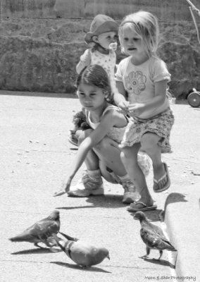 Girls feeding pigeons