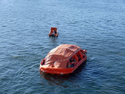 Life raft being towed by rescue boat after the drill