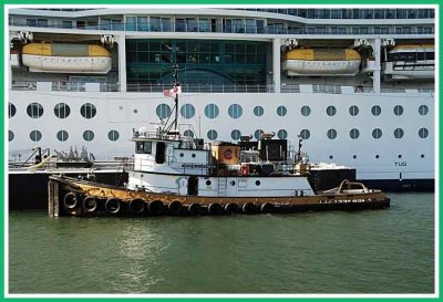 Tugboat working alongside cruise ship.