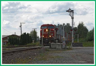 CP Rail powering thru a level crossing .