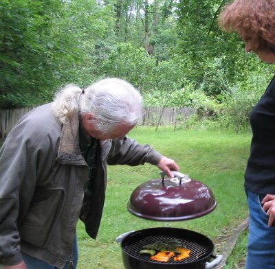 vince checks the bbq with sarah.