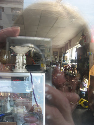 susan reflected in a junk store window