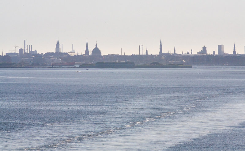 Lrdag, avreise fra Kbenhavn. Kongens by svinner hen akterut, badet i aftensolen.