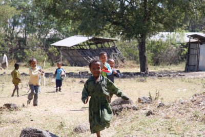 Children run to investigate us as we hike by their school