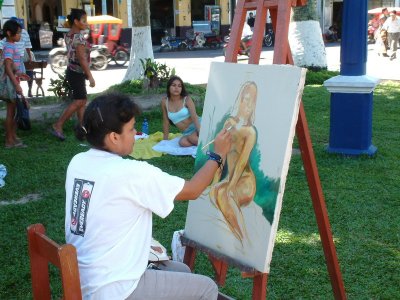An artist paints a model in Iquitos
