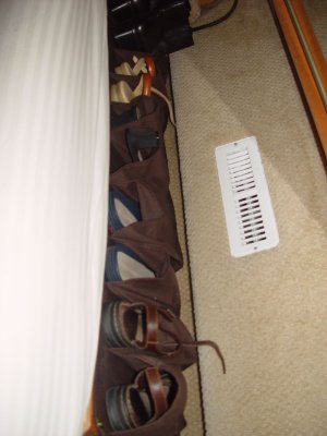 SHOE RACKS LINE THE SIDE OF THE BED