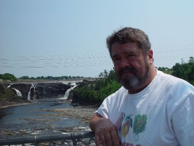 DON ON THE BRIDGE WITH THE FALLS IN THE BACKGROUND WITH HIS KNEES KNOCKING