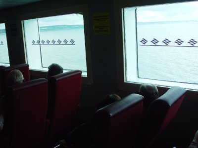 VIEW OUT THE SIDE WINDOWS OF THE FERRY WITH NOVA SCOTIA DISAPPEARING IN THE BACKGROUND