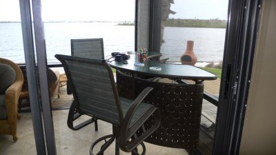 Rear screened porch with sliding windows, bar and wicker seating group