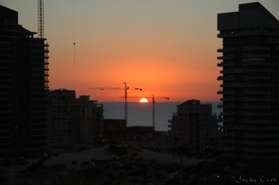 Sunset between the buildings in the construction site.