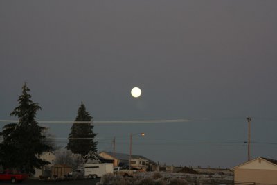 Street lights coming on under the Moon