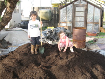 Cooper and Leila shoveling compost
