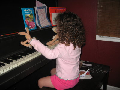 Leila playing piano with her bunnies