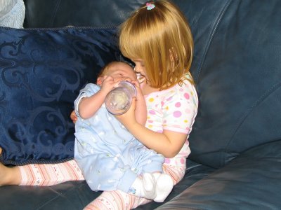 big sister feeding little brother