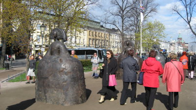 Ladies in Red and one statue of the series Las Meninas by the Spanish artist Manolo Valds in the Park Esplanade, Helsinki