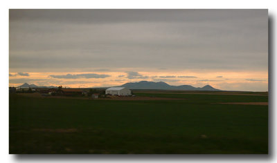 Dusk and the MOUNTAINS appear across this vast flatness!