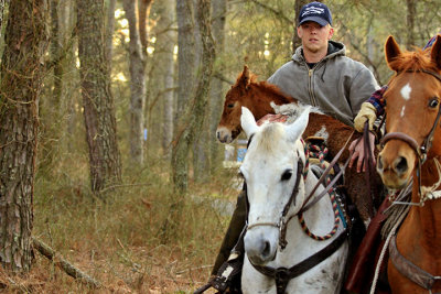 [APRIL 2007] A young saltwater cowboy carries the new foal after it was unable to keep up with the rest of the herd.
