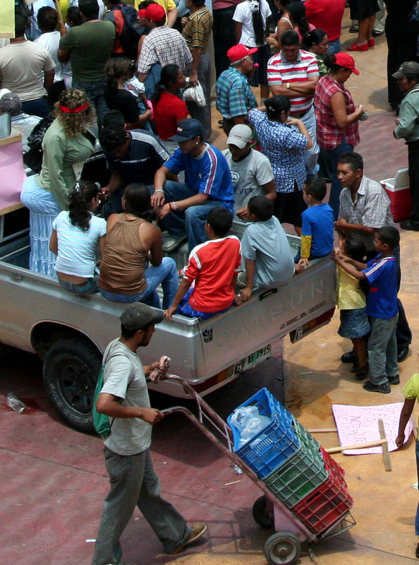 Close-up of the pickup truck and of the man with the hand cart.