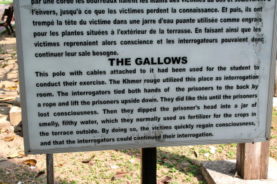 Sign describing the Tuol Sleng Prison gallows where the Khmer Rouge tortured people while interrogating them.