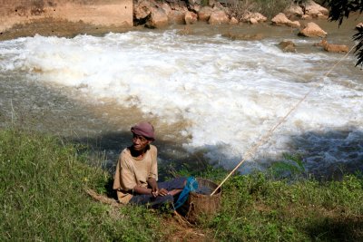An old fisherman next to the white water.