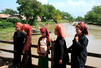 5 beautiful young Myanmar girls standing on a bridge.