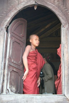 A monk at the door with a tourist inside.