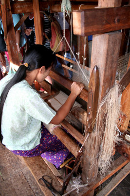 Young woman weaving fabric the traditional way.