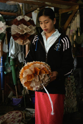 A young woman making a decoration out of Shan paper.