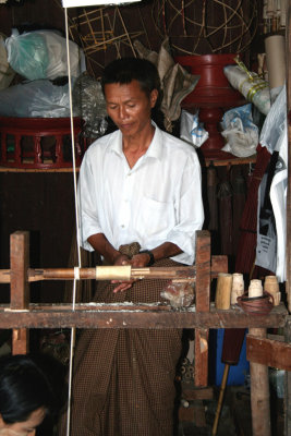 This man is using a lathe on bamboo which is used to make the parasols.