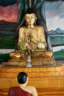 The statue in front appears to be praying to the Buddha.