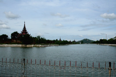 View of the palace moat with Mandalay Fort and Mandalay Hill in the distance.