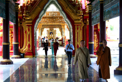 Monks and tourists passing through the entrance to the Kuthodaw Pagoda.